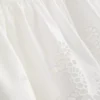 Cami-top i bomull med brodert peplum-kant