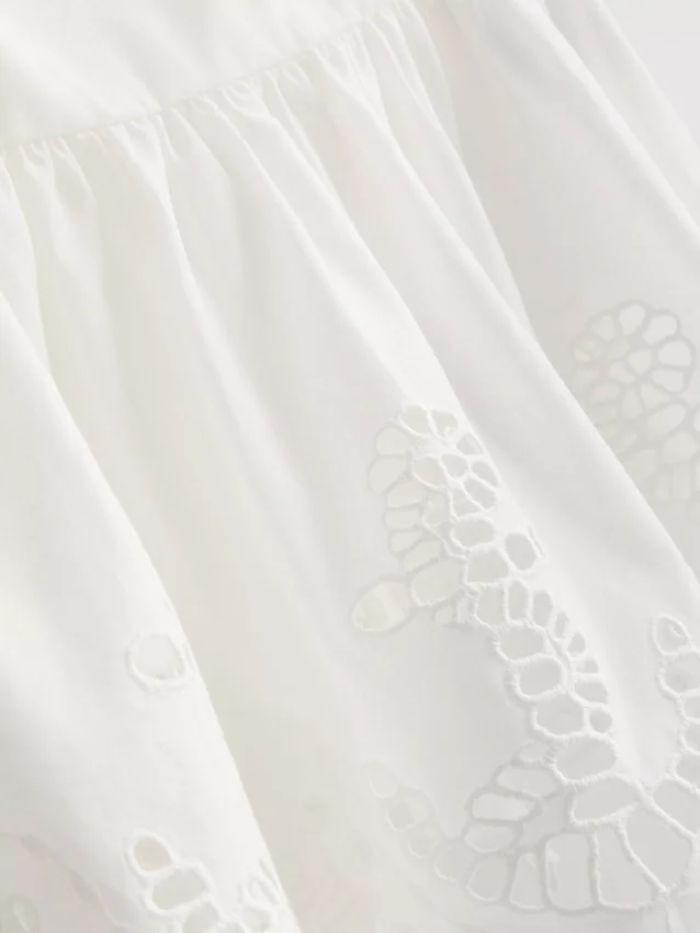 Cami-top i bomull med brodert peplum-kant