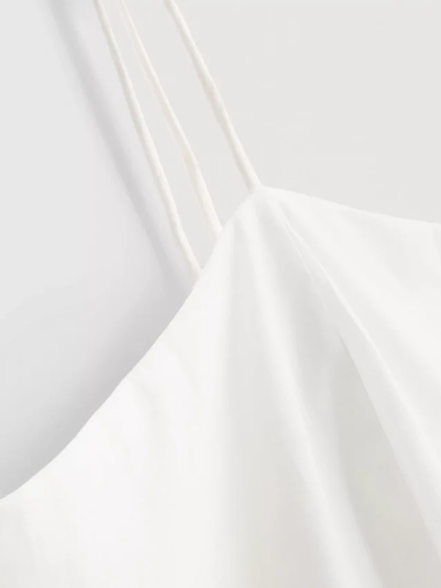 Cami-top i bomull med brodert peplum-kant