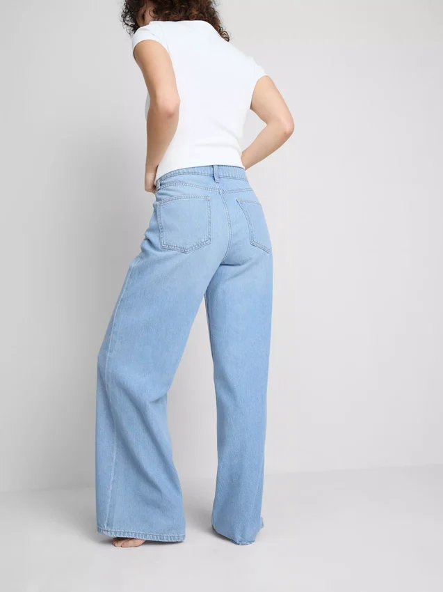 Jeans i bomullsdenim med middels høy midje og vide ben