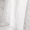 Top med broderi og bånd i siden